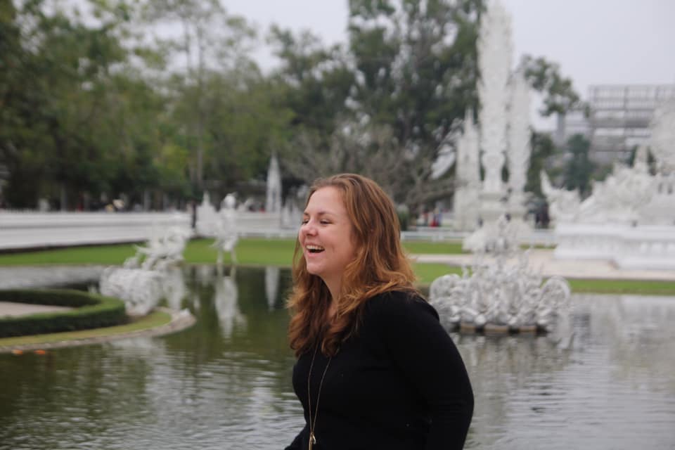 Lucy smiling in front of the Thai Wat Rong Khun